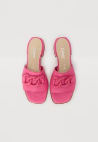 Pink leather slide sandals with a woven chain detail on the strap, open heel, and square toe design. Flat sole and cushioned insole.