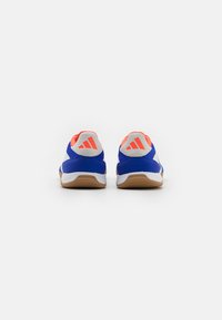 Zapatillas deportivas azules con acentos en blanco y naranja, parte superior texturizada, talón acolchado y suela de goma, con un logo de la marca en el talón.