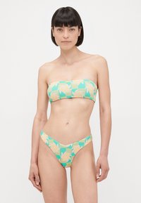 Virágmintás bikini szett, bandeau felsővel és magas combkivágású alsóval, zöld, sárga és barack árnyalatokban. Sima, rugalmas anyag.