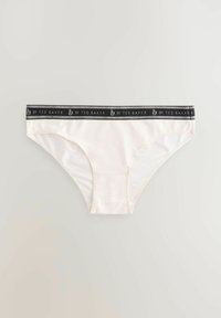 White cotton bikini underwear with a black elastic waistband featuring "by Ted Baker" printed in silver text. Smooth texture, minimalist design.