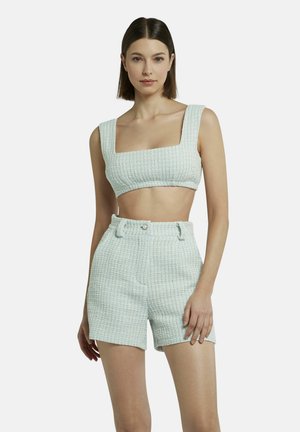 Lichtblauw textuur tweedelig set dat bestaat uit een crop top met vierkante halslijn en high-waisted shorts, beide met een geweven patroon en twee knopen.