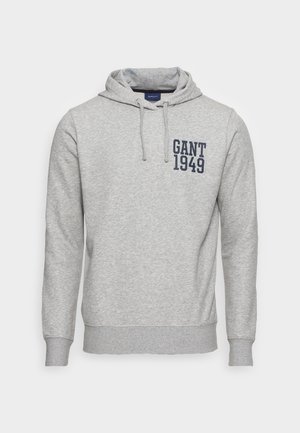 Sweat à capuche gris clair avec cordons, manches longues et « "GANT 1949" » imprimé en bleu marine sur le haut gauche de la poitrine.