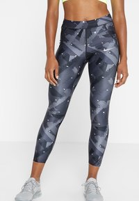 Legginsy w czarno-szare wzory z wysokim stanem, charakteryzujące się geometrycznymi akcentami i gładką, elastyczną strukturą materiału.