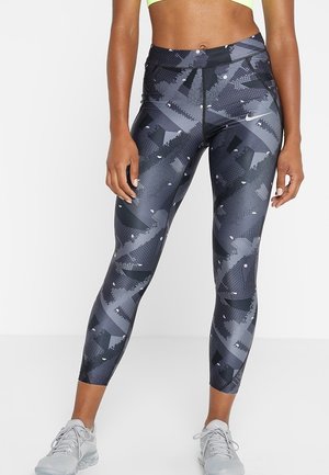 Legginsy w czarno-szare wzory z wysokim stanem, charakteryzujące się geometrycznymi akcentami i gładką, elastyczną strukturą materiału.