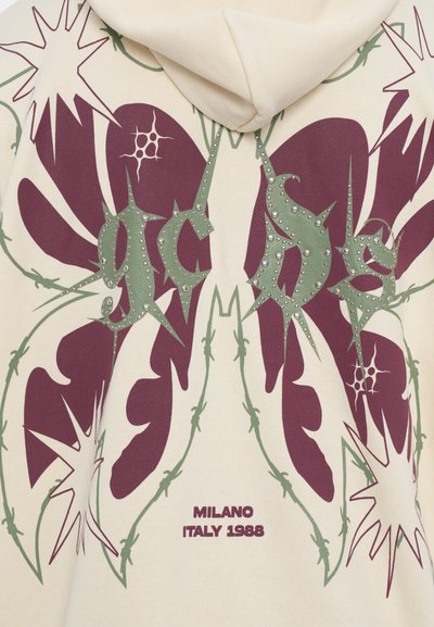 Hooded sweatshirt in cream featuring large purple and green botanical graphic with spiked accents and "Milano Italy 1988" text.