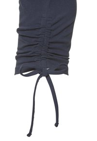 Tumesinine puuvillane rõivas, millel on kogutud tekstuur ja elastne detail. Omab sidet alaosas, et reguleerida sobivust. Sile kangas.