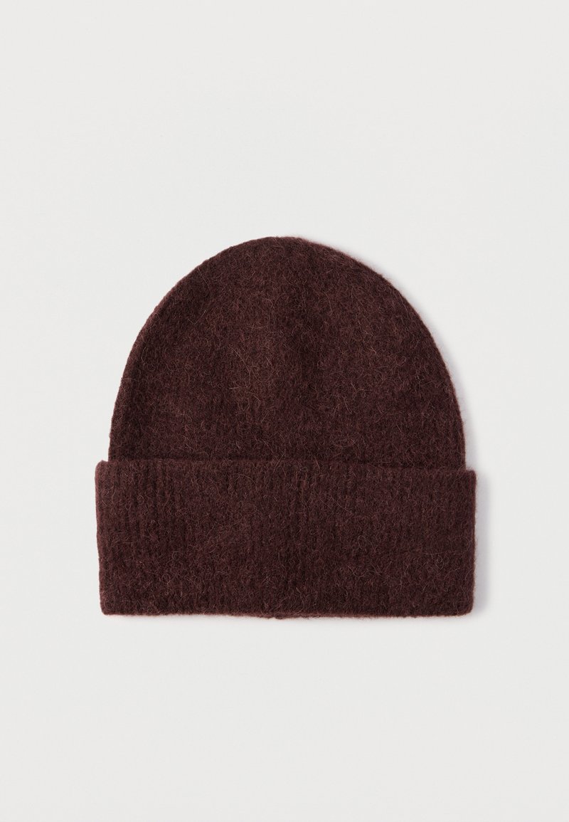 Burgundy knitted beanie with a soft, textured finish and a wide folded cuff at the base. Round, seamless top design.