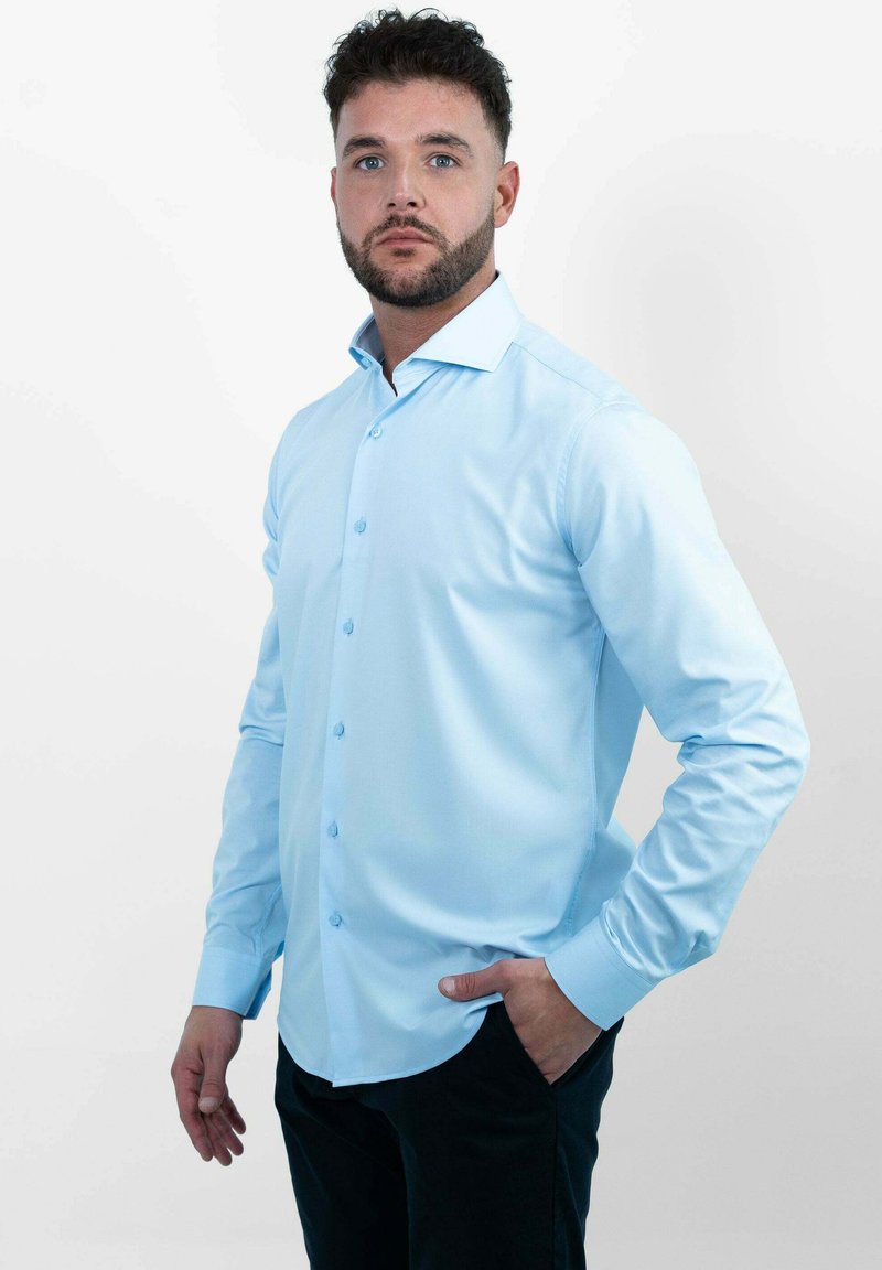Lichtblauw overhemden met lange mouwen, aansluitend ontwerp en afgeronde zoom. Voorzien van bijpassende knopen en een klassieke kraag.