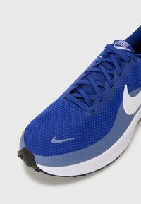 Blauer Mesh-Laufschuh mit einer strukturierten Oberfläche, weißem Swoosh-Logo und kontrastierenden hellblauen Akzenten. Verfügt über eine schwarze Gummisohle.
