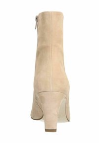 Botte de cheville en suède beige avec un bout rond, un talon bloc de hauteur intermédiaire et une fermeture éclair sur le côté pour faciliter l'enfilage. Texture lisse avec une finition propre.