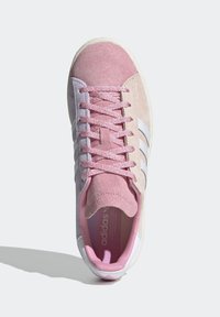 Růžové semišové tenisky s texturovaným povrchem, bílým designem tří pruhů a odpovídajícími růžovými tkaničkami. Obsahují polstrovaný jazyk a límec.