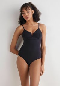 Zwart badpak met dunne verstelbare bandjes, V-hals en gestructureerde bodice. Glad, soepel textuur met minimale details.