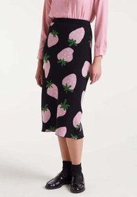 Falda lápiz de punto en negro con patrones de fresas rosas y tallos verdes. Corte a media longitud, cintura elástica y diseño ajustado.