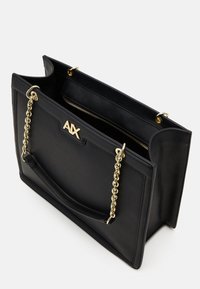 Bolso tote de cuero negro con acabado texturizado, correa de cadena dorada y logo de marca. Incluye un compartimento interior con cremallera.