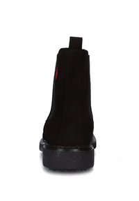 Stivaletti alla caviglia in suede nero con finitura liscia, dotati di linguetta per la calzata e suola in gomma texturizzata. Design elegante e minimalista con dettagli sottili.