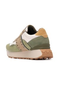 Zapatilla con un diseño en capas en tonos verde, beige y ante blanco roto. Presenta una suela acolchada y acentos perforados.