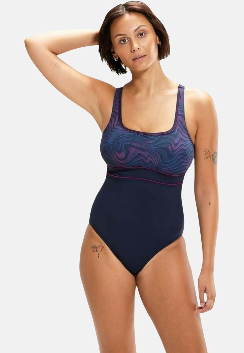 Costume da bagno intero blu navy con parte superiore a motivi ondulati viola, scollatura quadrata e spalline regolabili, realizzato in materiale liscio ed elastico.