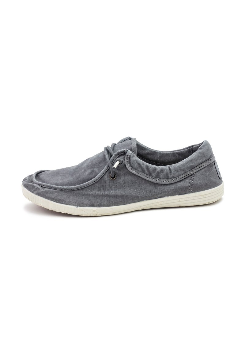 Scarpa di tela grigia con punta rotonda, lacci elastici e suola in gomma bianca. Presenta una texture morbida e dettagli cuciti.