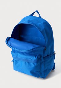 Kék hátizsák tartós anyagból, nagy főrekesszel, elöl cipzáras zsebbel és felső fogantyúval a könnyű hordozásért.
