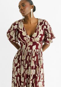 Burgundy dress with a deep V-neck and flutter sleeves, featuring gold floral embroidery and a flowing pleated skirt.