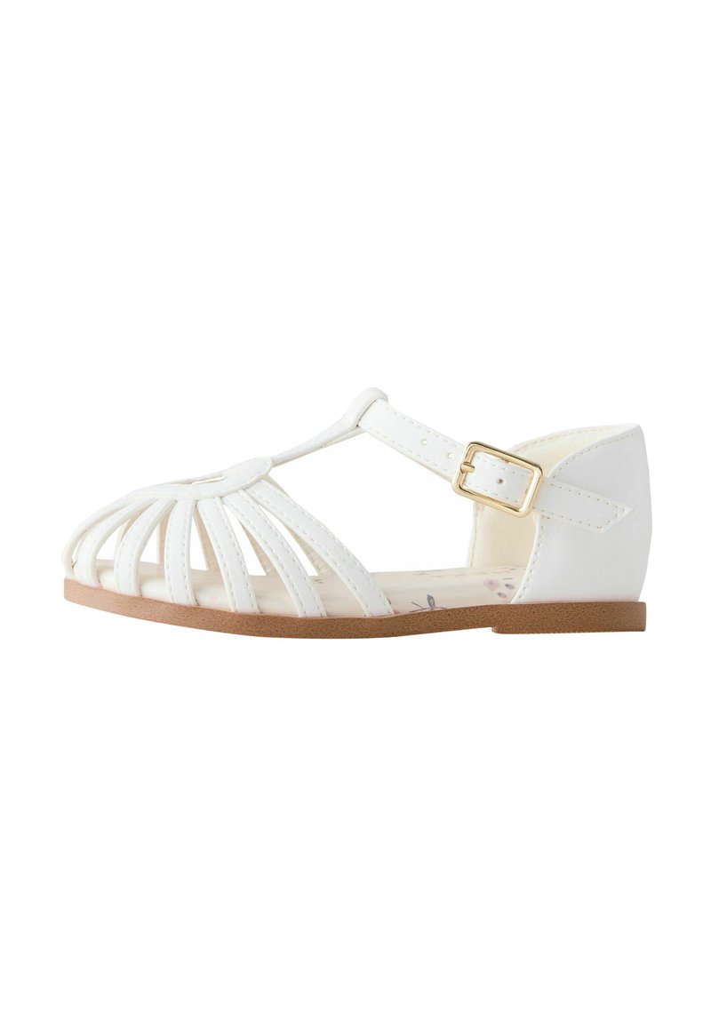 White sandal with multiple vertical straps, adjustable buckle, and a flat sole. Features a floral-patterned insole. Smooth synthetic material.