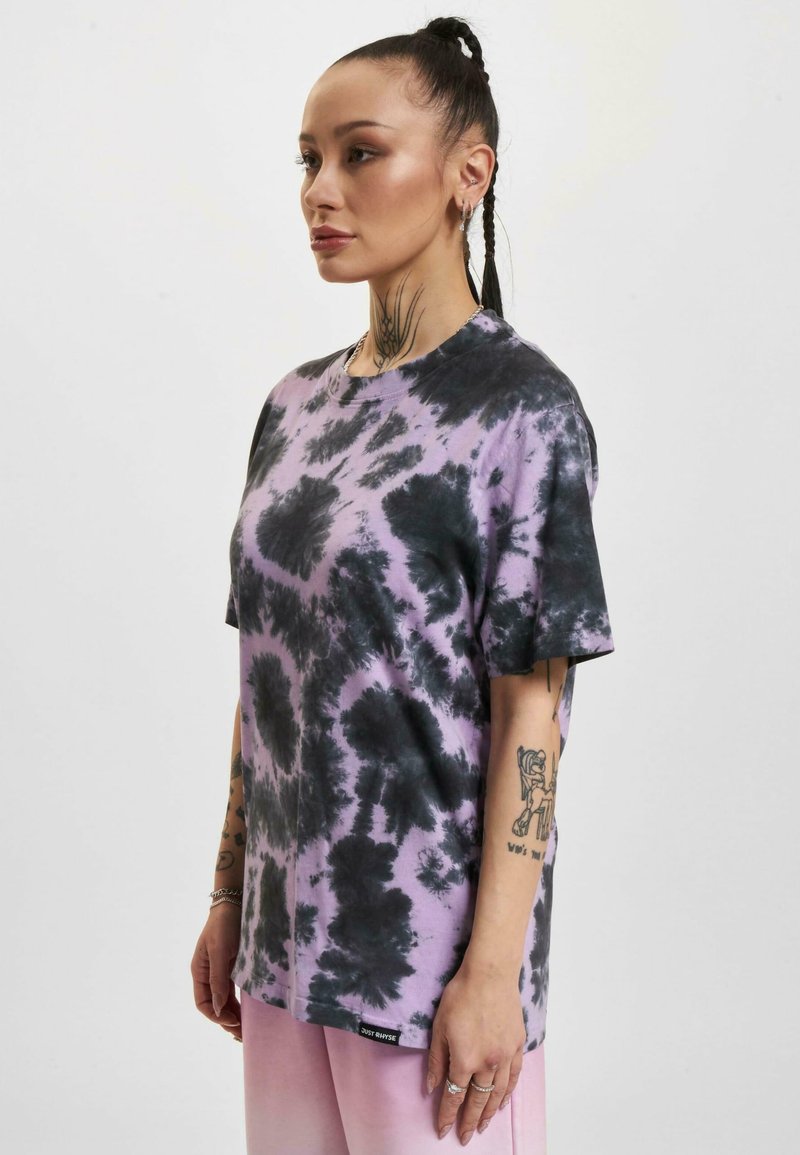 Tricou tie-dye în nuanțe de violet și negru, cu mâneci scurte, decolteu rotund și croială lejeră. Prezintă o etichetă mică cu logo la tiv.