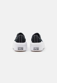 Černé plátěné nízké tenisky s bílou gumovou podrážkou, kontrastním bílým šitím a logem "Converse All Star" na patě.