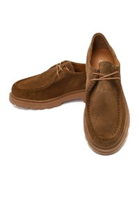 Brown suede shoes with a rounded shape, lace-up design, and thick rubber sole. Notable stitching along the edges adds texture.