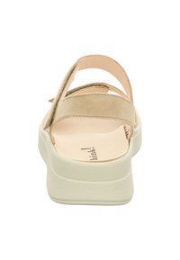 Beige Wildledersandalen mit mehreren dünnen Riemen, leicht gepolsterter Innensohle und einer strukturierten weißen Sohle. Ansicht von hinten, die das Fersen-Design zeigt.