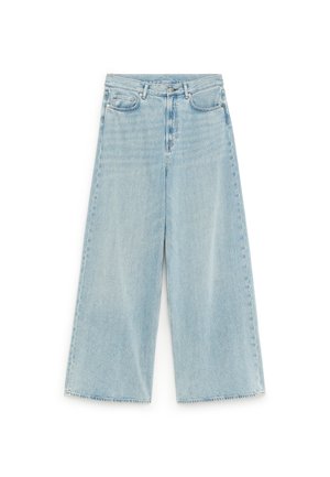Jean denim bleu clair à jambes larges avec taille haute, fermeture avant par boutons et fermeture éclair, et style cinq poches.