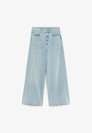 Jean denim bleu clair à jambes larges avec taille haute, fermeture avant par boutons et fermeture éclair, et style cinq poches.