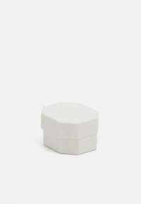 Caja hexagonal blanca con una textura suave, que presenta una tapa que se ajusta perfectamente sobre la base. Diseño minimalista sin patrones ni acentos.