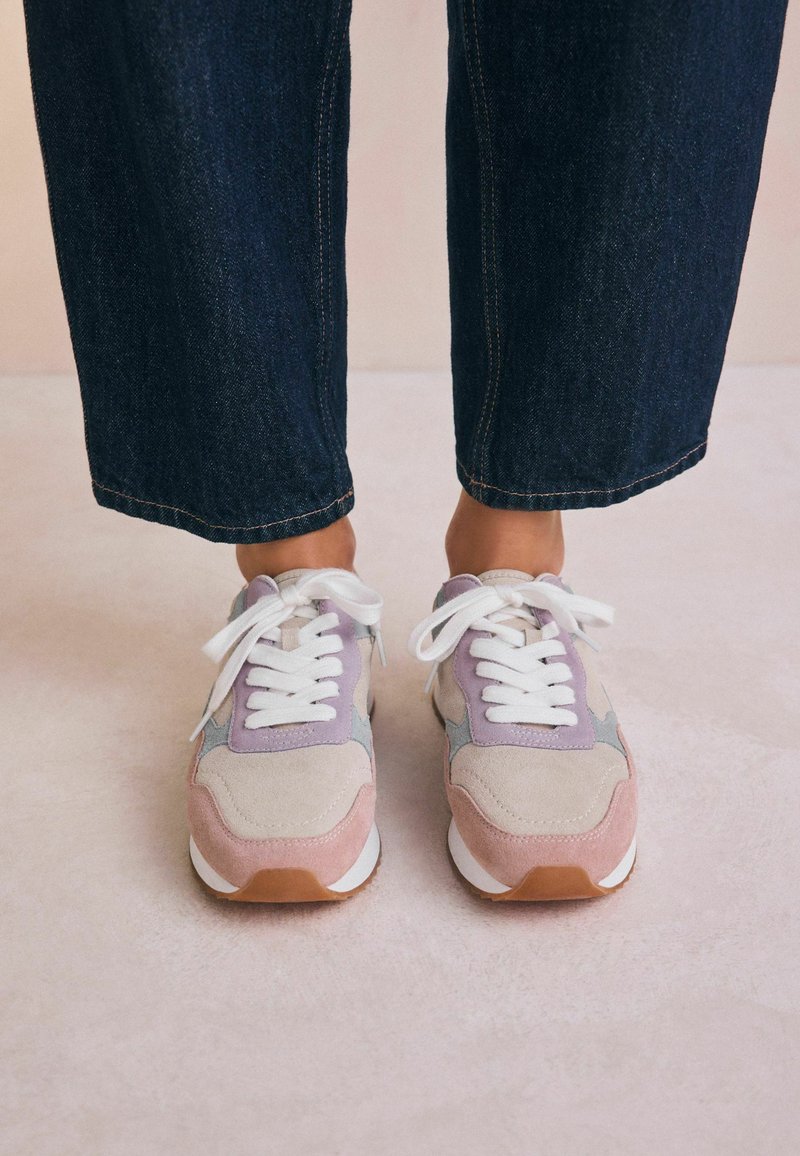 Sneakers in pink, gray, and lavender suede with white laces and a brown rubber outsole. Designed with a sporty silhouette and textured panels.