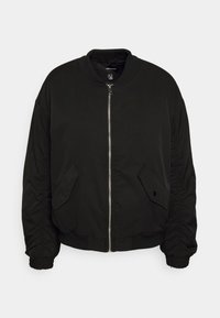 Veste bomber noire avec fermeture éclair avant, deux poches à rabat inclinées avec boutons, col, poignets et ourlet côtelés, et manches longues froncées.