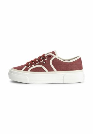 Lage bordeauxrode canvas sneaker met witte bies, dikke witte zool en veters, gezien vanaf de buitenkant.