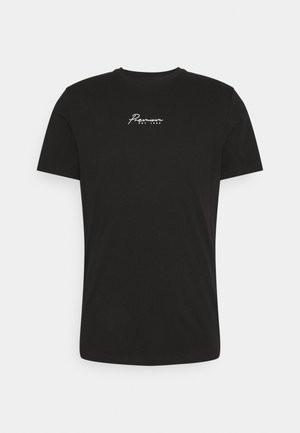 Czarny t-shirt z krótkim rękawem i okrągłym dekoltem, z białym, kursywnym napisem "Premium EST 1990" na środku klatki piersiowej.