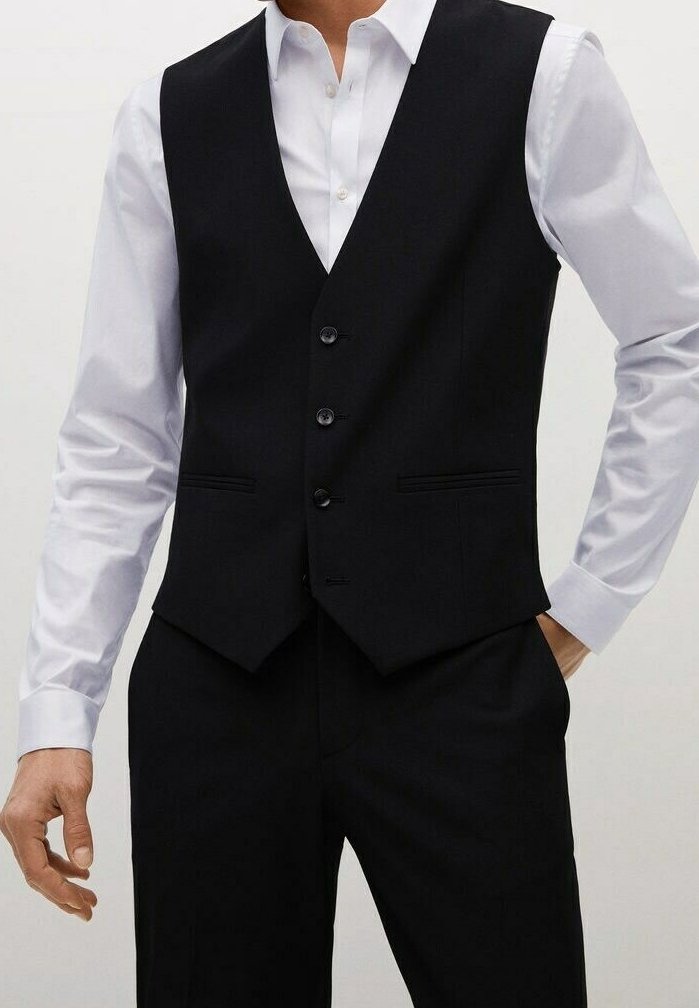 Gilet nero su misura con un design aderente, dotato di quattro bottoni, due tasche frontali e una superficie liscia, indossato sopra una camicia bianca.