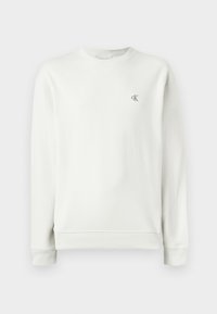 Lys grå genser med rund hals laget av glatt stoff, med ribbestrikkede mansjetter og kant, og et lite brodert logo på brystet.