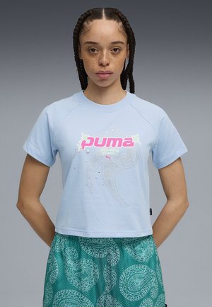Jasnoniebieski krótki t-shirt z różowym logo "PUMA" i dekoracyjnymi akcentami graficznymi; krótki rękaw i luźny krój.