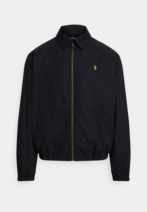 Black zip-up jacket with a collar, elastic cuffs, and hem, featuring a small gold logo on the left chest. Made of smooth fabric.