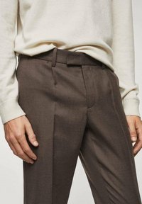 Pantaloni su misura marroni con taglio dritto, caratterizzati da una superficie liscia, tasche laterali e passanti per cintura per una vestibilità sicura.