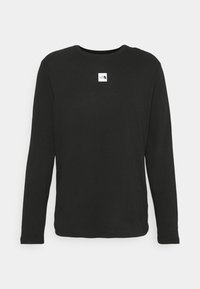 Černé tričko s dlouhým rukávem vyrobené z bavlny, s kulatým výstřihem a malou bílou nášivkou logo na horní levé části přední strany.