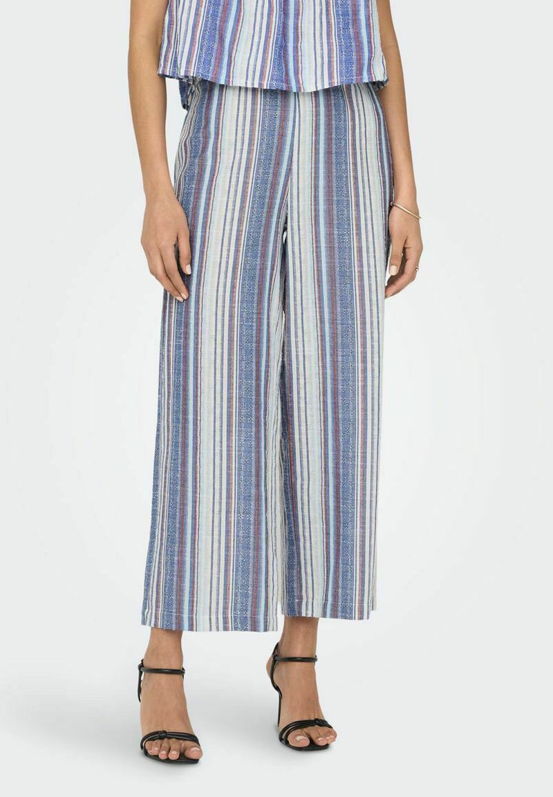 Pantaloni leggeri a gamba larga con strisce verticali blu, bianche e rosse. Presentano un tessuto testurizzato e una vestibilità ampia.