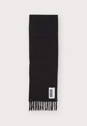 Écharpe noire texturée avec des franges, arborant une étiquette blanche avec le logo "DRYMORN". Forme rectangulaire, matériau doux.