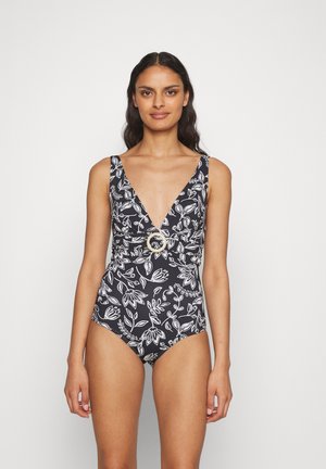 Costume intero nero con motivo floreale bianco, scollatura a V profonda, spalline larghe, vita arricciata con dettaglio in metallo circolare.