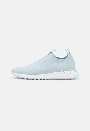 Jasnoniebieskie sneakersy typu slip-on z dzianinową cholewką, białą amortyzowaną podeszwą, teksturowanym bieżnikiem i pętlami do ściągania z tyłu i na języku.