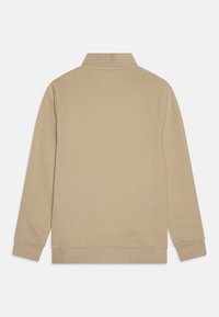 Μπεζ πλεκτό με γιακά, μακριά μανίκια και ριγωτά μανίκια. Φτιαγμένο από ομαλό ύφασμα με μίνιμαλ σχεδίαση και χωρίς ορατά μοτίβα ή αξεσουάρ.