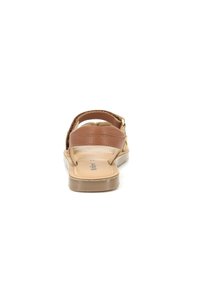 Sandalias de cuero marrón con una correa trasera, plantilla acolchada y suela de goma marrón clara. Las características incluyen doble correas para soporte y comodidad.