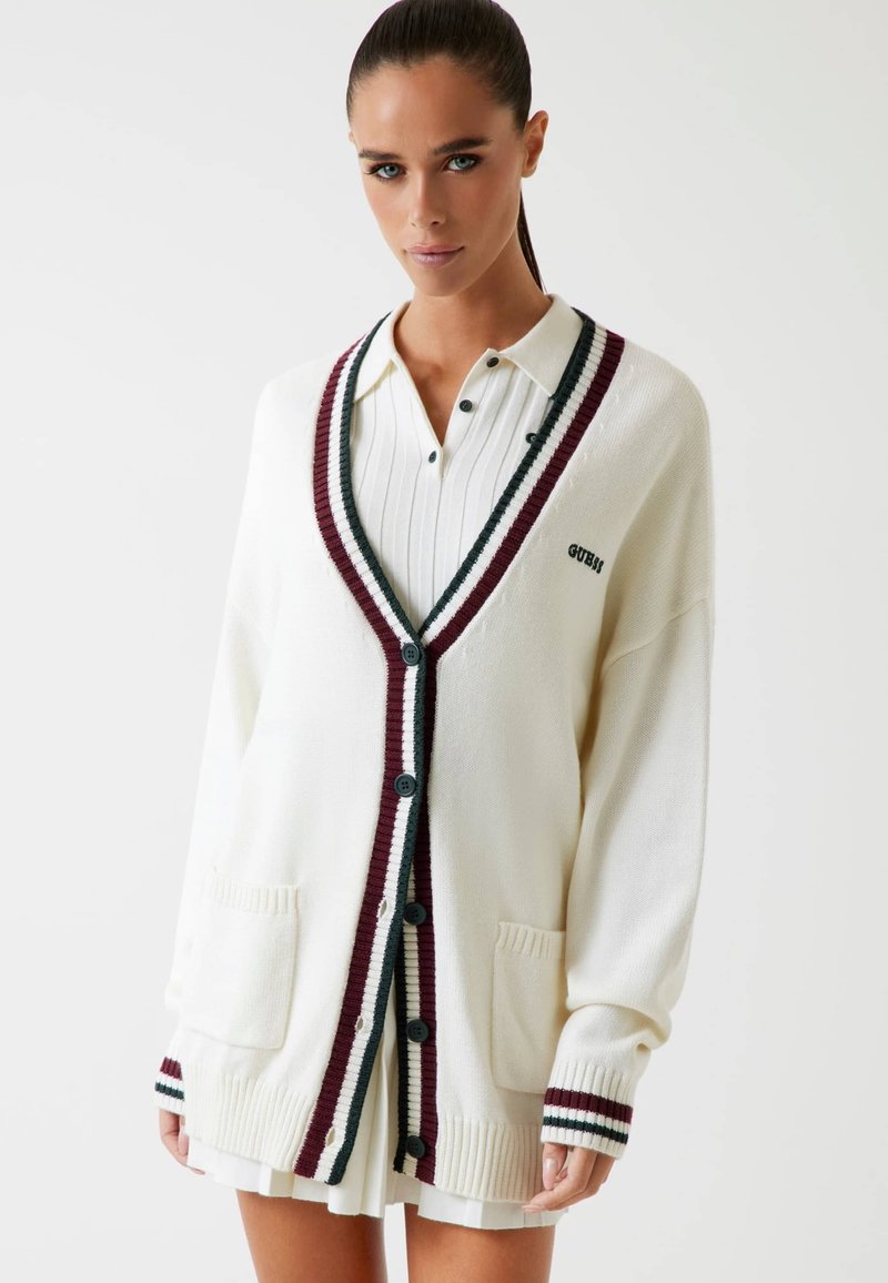 Cardigan bianco lavorato a maglia con accenti a costine in bordeaux e verde, chiusura con bottoni, due tasche anteriori e una vestibilità comoda.
