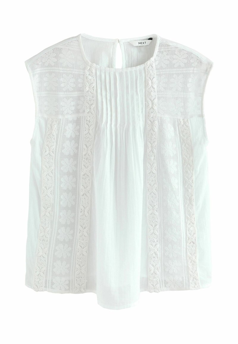 Blouse blanche à manches courtes, ornée de broderies délicates et de détails plissés. Tissu doux avec une fermeture en goutte d'eau au dos.